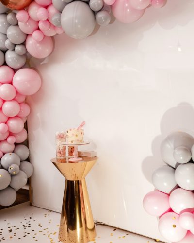 Delicious wedding reception. Birthday Cake on a background balloons party decor